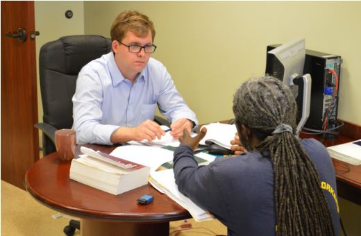 Bradley sits with a local citizen during a Counsel on Call session. Photo courtesy of Lafayette Bar Association